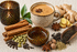 Warmes Duftbild mit Chai-Tee, Zimtstangen, Kardamom, Sternanis und gemütlicher Gewürztee-Atmosphäre auf hellem Hintergrund für Chai Tea Fragrance Oil