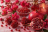 Intensives Duftbild mit Granatapfel, Granatapfelkernen und dunklen pinken Blüten auf hellem Hintergrund für Pomegranate Intense Fragrance oil
